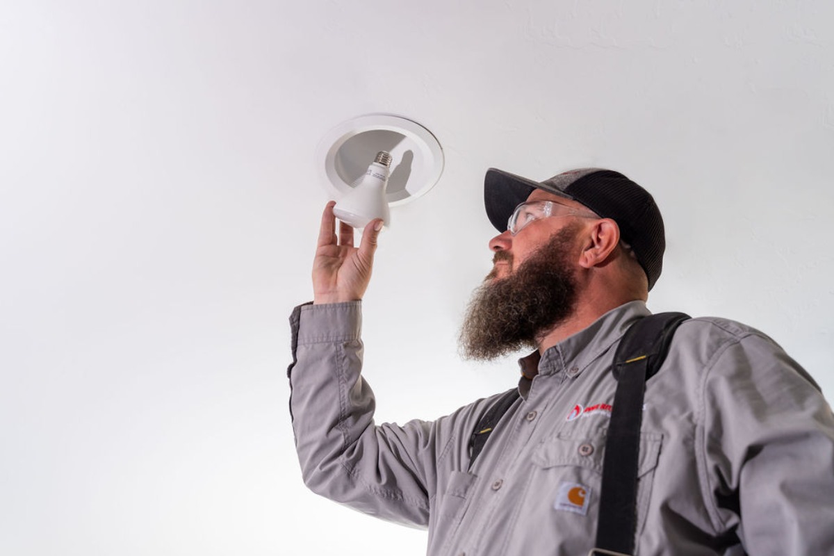Tucson electrician from Done Right Services expertly installing a new lightbulb in a residential home.