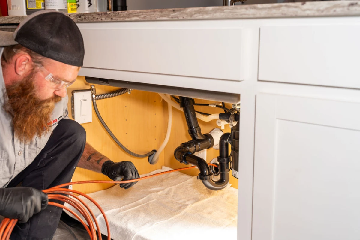 Expert plumber from Done Rite Services working under the sink for emergency drain unclogging in Tucson homes.