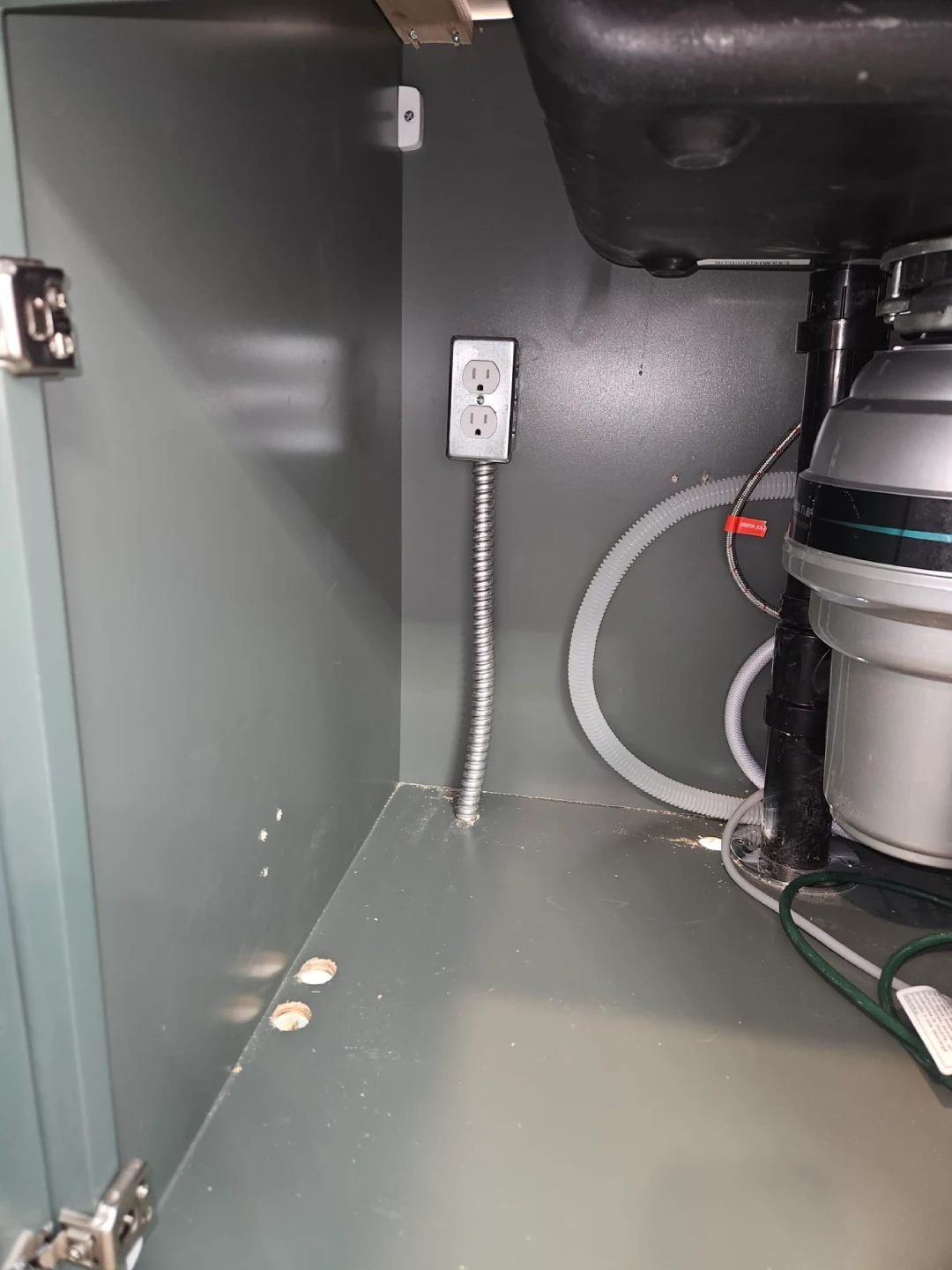 Done Rite Service technician expertly installing a new garbage disposal unit under a kitchen sink, ensuring functionality and durability.