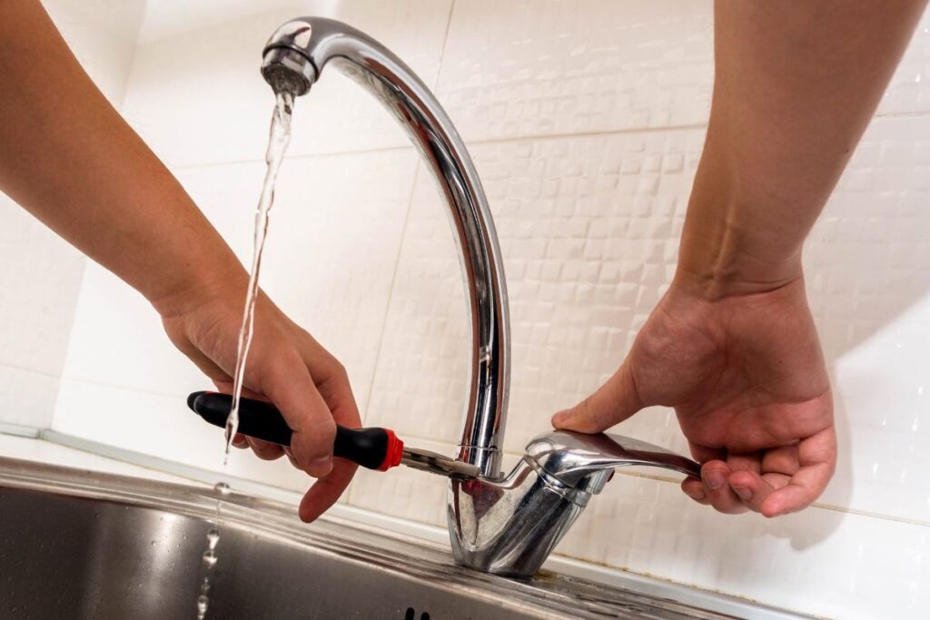 Done Rite Services plumber efficiently repairing a leaky kitchen faucet in a Tucson home, ensuring durability.