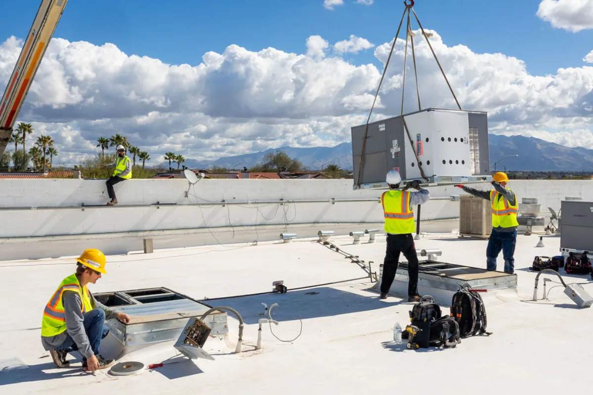 Done Rite Services HVAC technician installing an air conditioner on a commercial building rooftop.