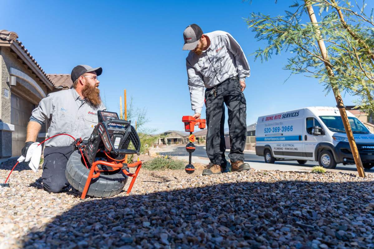 Done Rite Services expert plumbers performing a thorough outdoor emergency plumbing inspection.