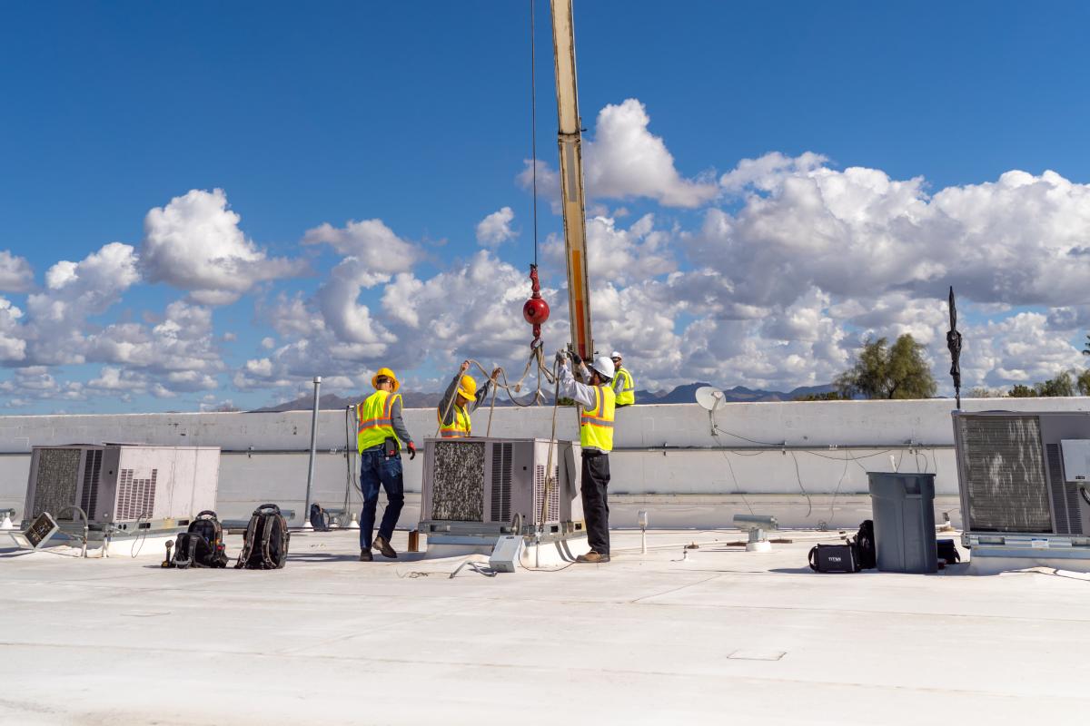 HVAC technicians from Done Rite Services performing air conditioner installation on a commercial rooftop in Catalina Foothills.