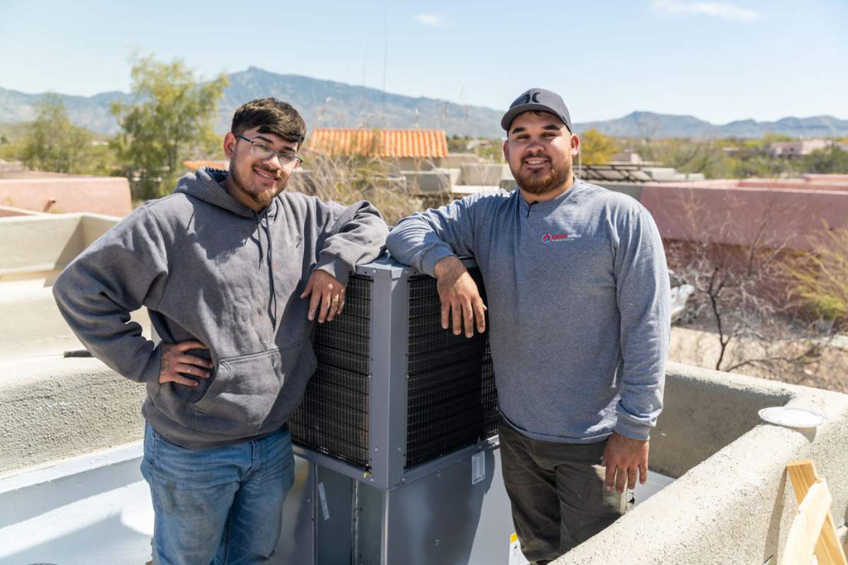 Team from Done Rite Services standing next to a newly installed AC compressor on a commercial rooftop