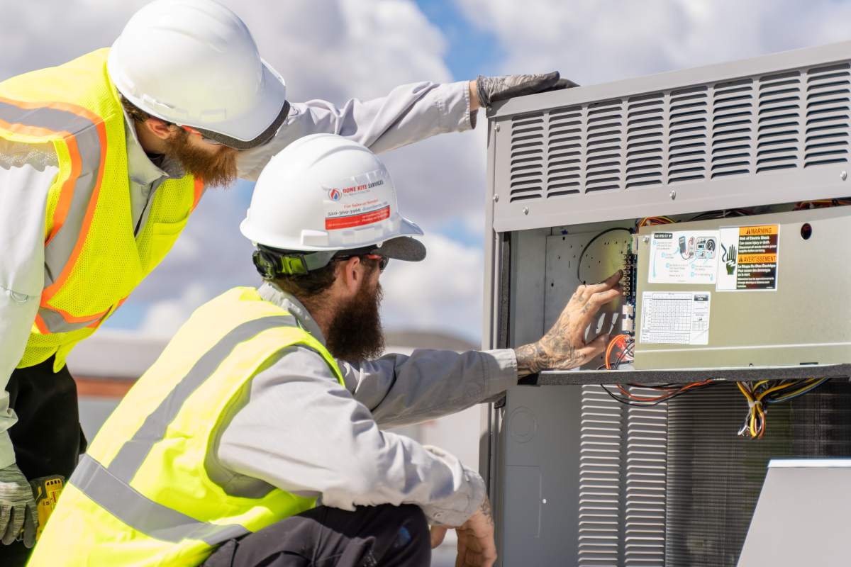 Done Rite Services HVAC experts performing air conditioner repair on the roof of a commercial building in Saddlebrooke.