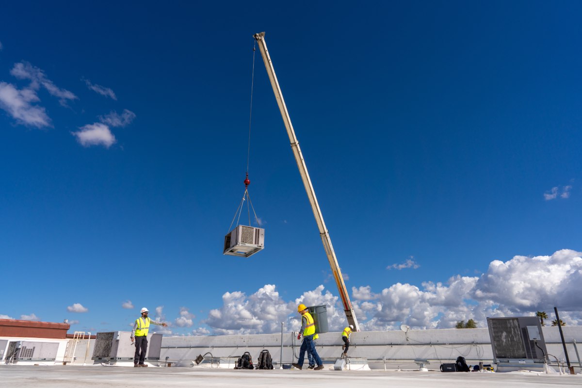 Done Rite Services HVAC technicians installing an air conditioning unit on a commercial rooftop in Marana.