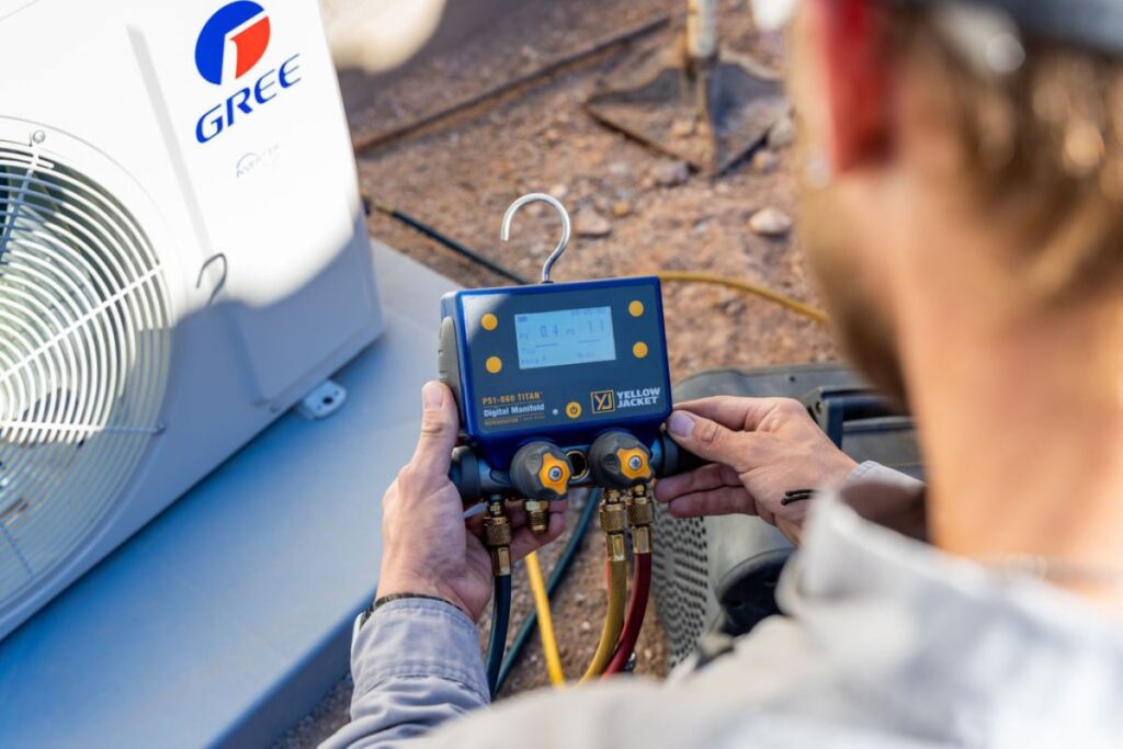 HVAC technician from Done Rite Services inspecting refrigerant levels in an AC unit to prevent coil freezing.