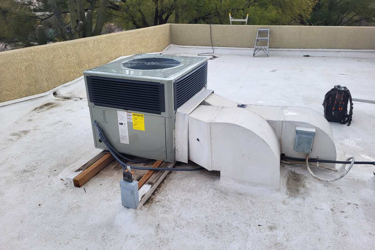 HVAC experts from Done Rite Services repairing an air conditioning unit on the roof