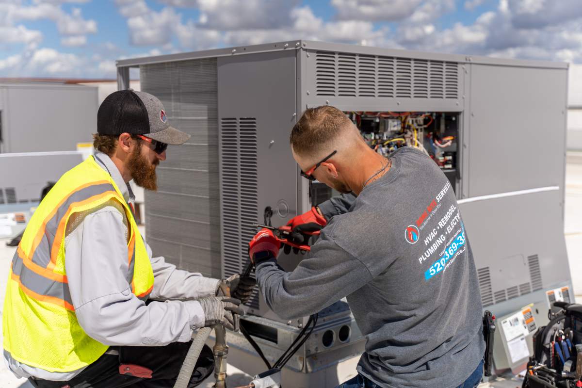 Done Rite Services HVAC technicians repairing an air conditioning unit on the roof of a commercial building in Saddlebrooke.