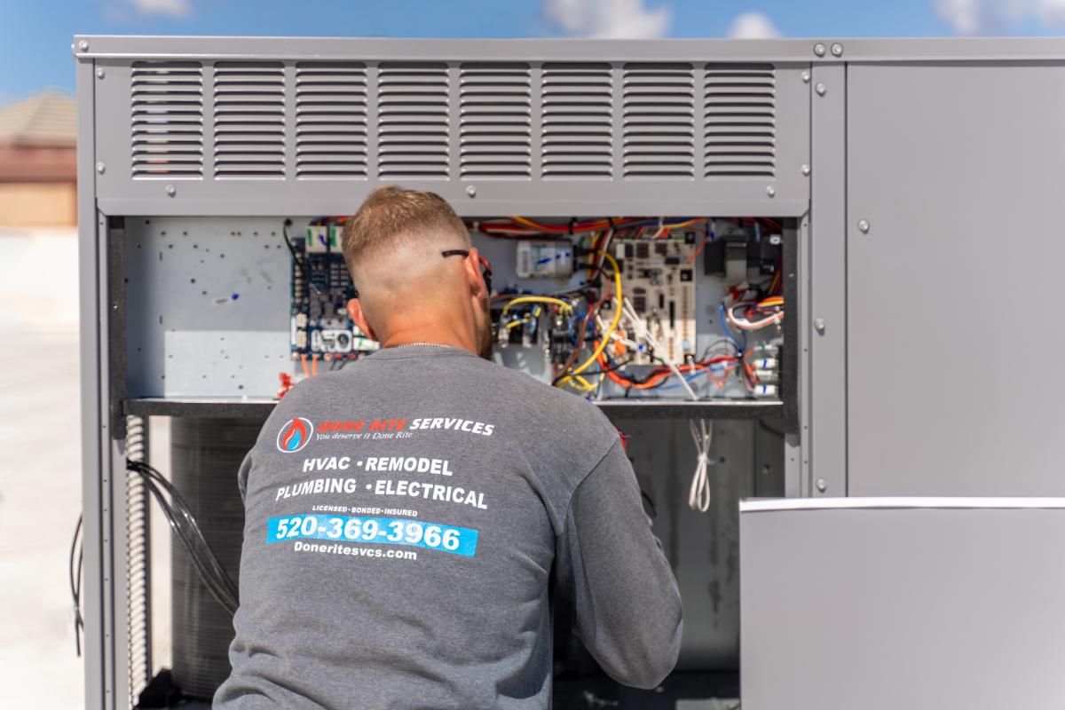 Done Rite Services technician working on air conditioning installation on a commercial rooftop in Casa Adobes.