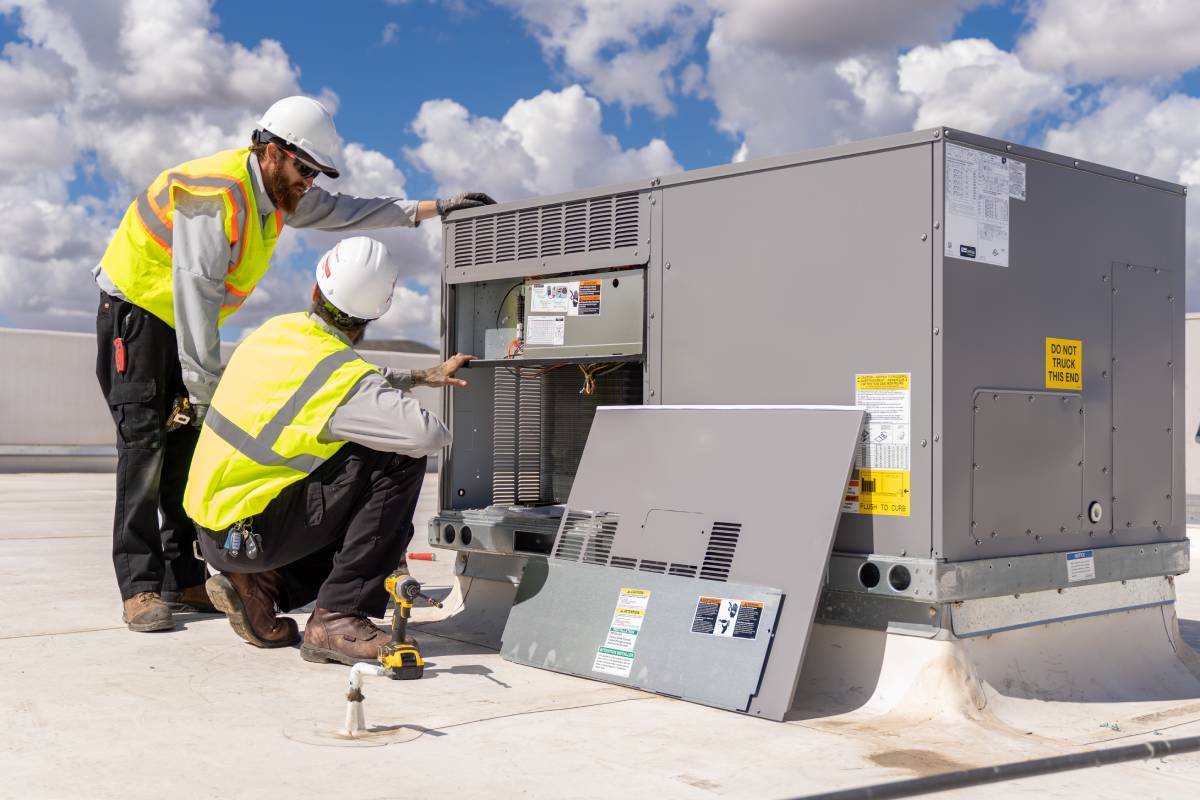 Done Rite Services technicians installing an air conditioning unit on the roof of a commercial building in Casa Adobes.