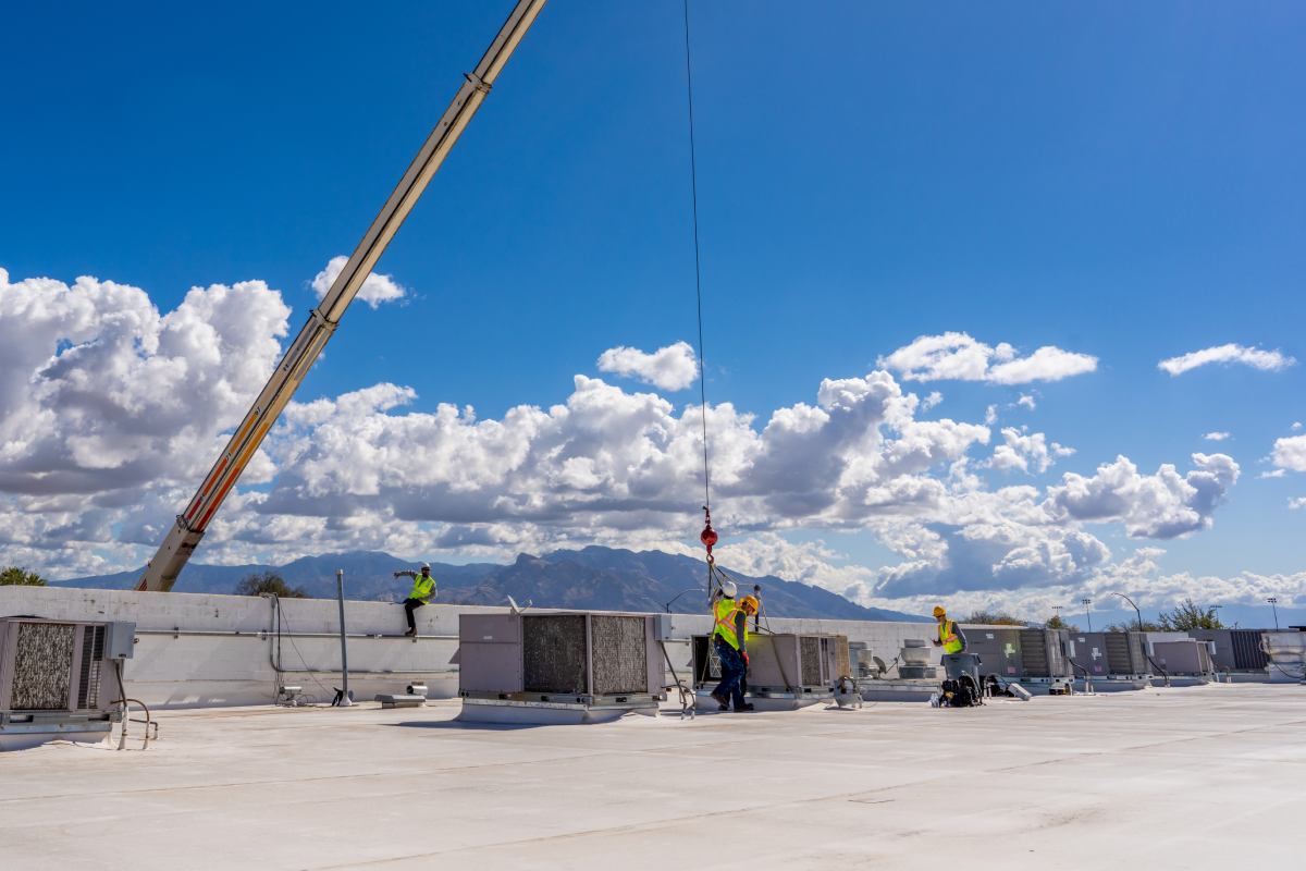 Done Rite Services team installing an air conditioner on the roof of a commercial building in Casa Adobes