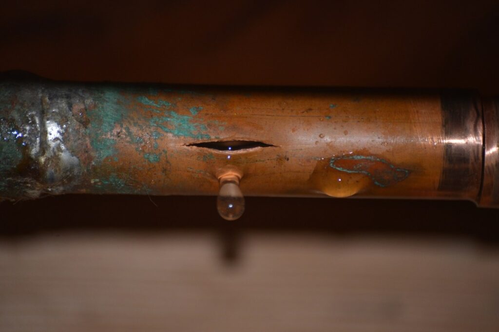 Close-up image of a broken pipe showing water leaking