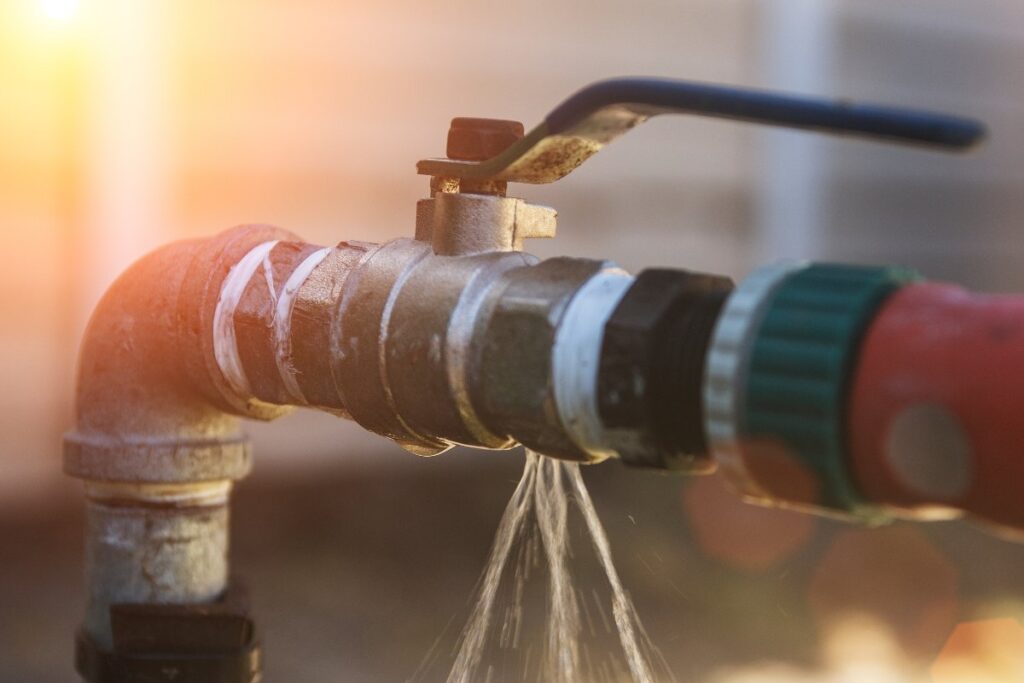 Close-up of a leaking water pipe with visible water dripping