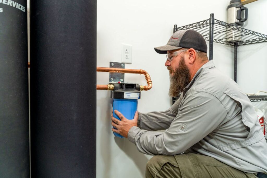 Done Rite Services expert plumber installing a water softener in a Tucson home as part of an eco-friendly plumbing upgrade.