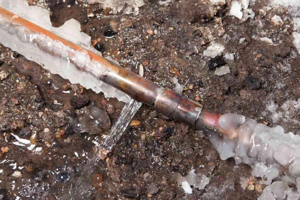 Frozen water pipes with visible cracks and leaks due to neglected winterization.