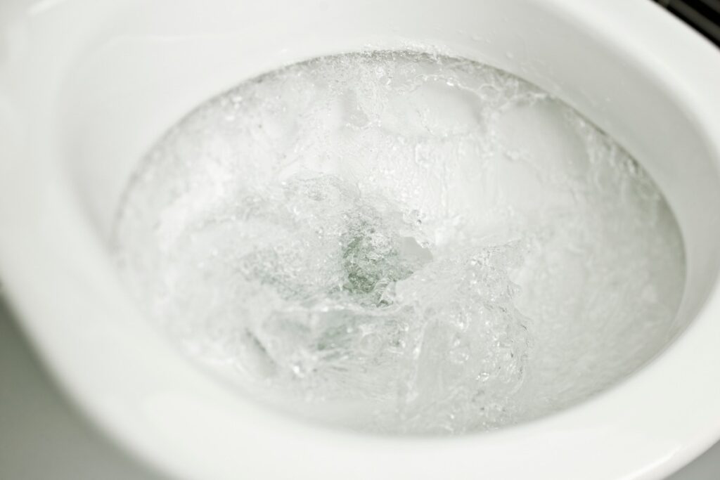 Toilet bowl with water swirling during a flush, illustrating the importance of preventing overflow.