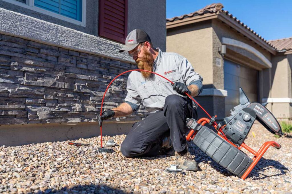 Plumber from Done Rite Services using specialized equipment for a sewer line inspection in a Tucson home.