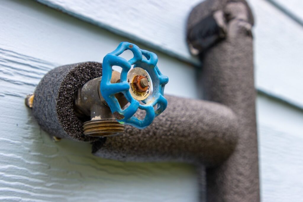 Close-up of pipes being insulated as part of winter plumbing preparation for cold weather.