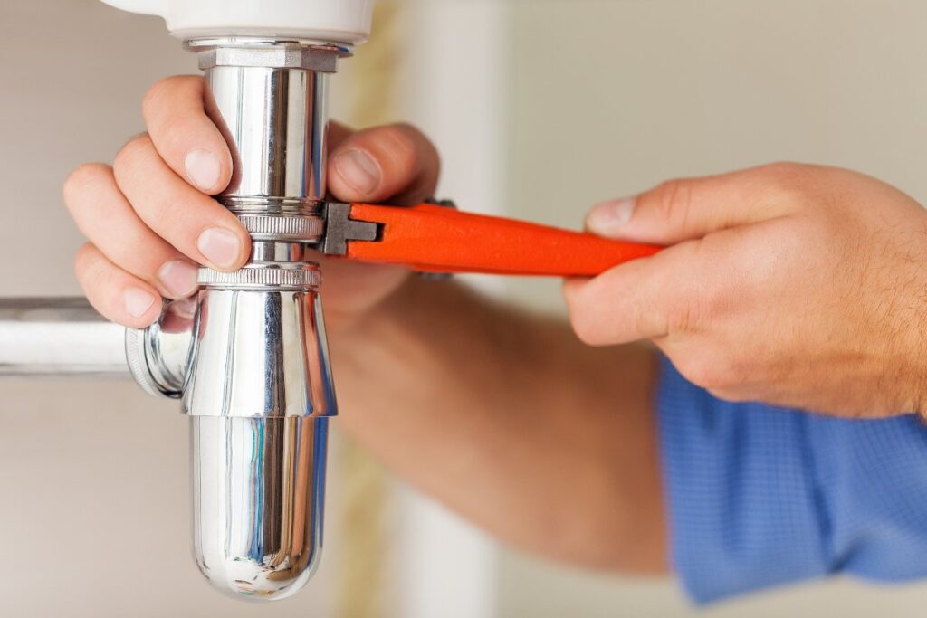 Expert plumber from Done Rite Services fixing the drain seal under a residential sink to stop leaks