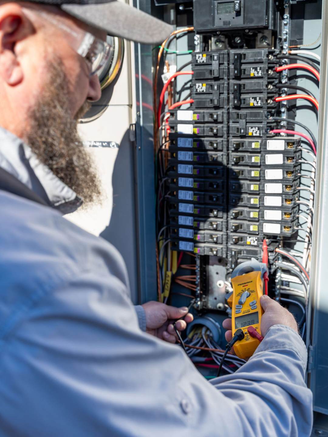 Oro-Valley-Electrical-Inspection Done Rite Services expert electrician in Tucson checking voltage on a panel during an electrical inspection.